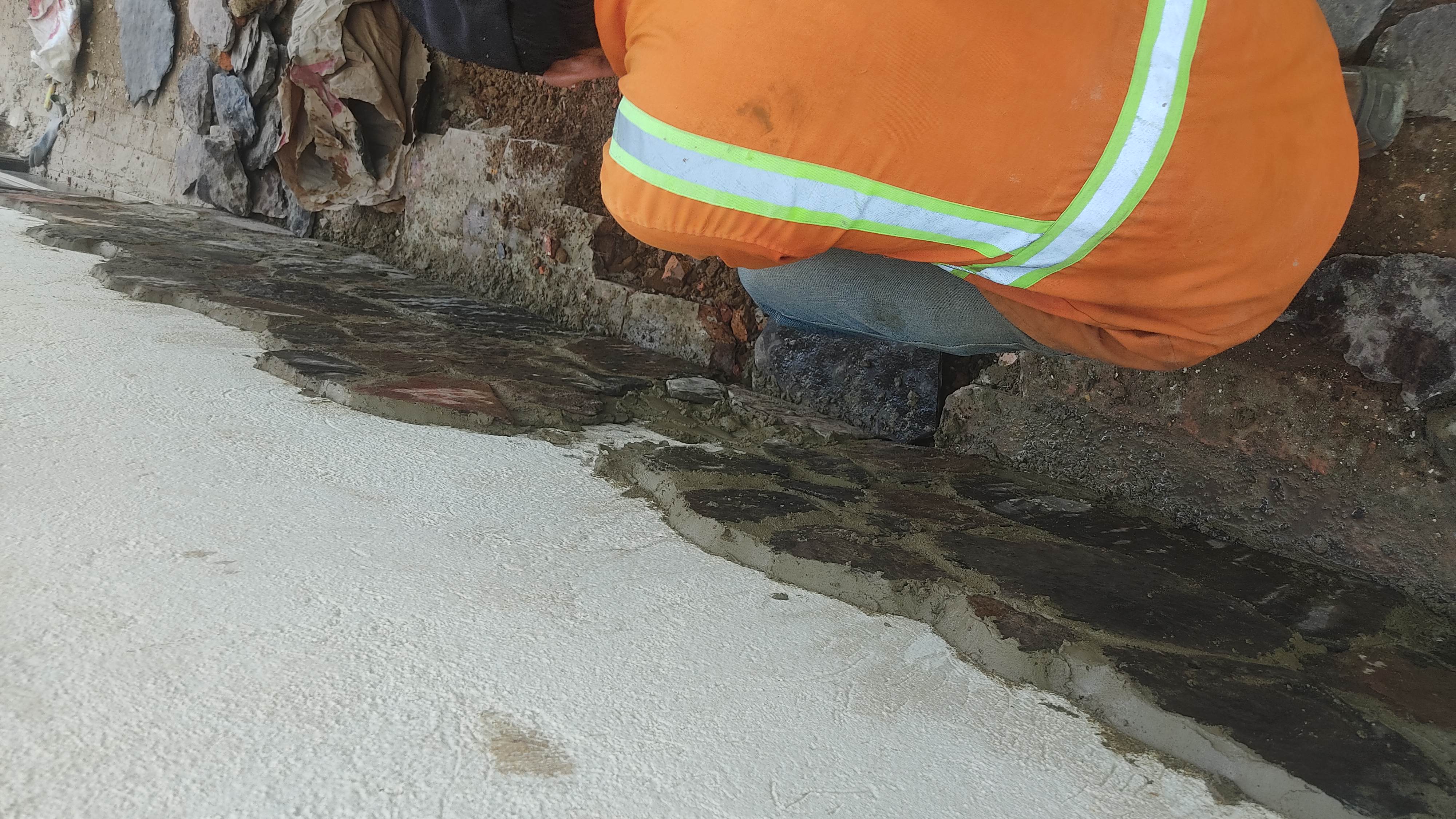 Installing stone cladding along the base of a wall